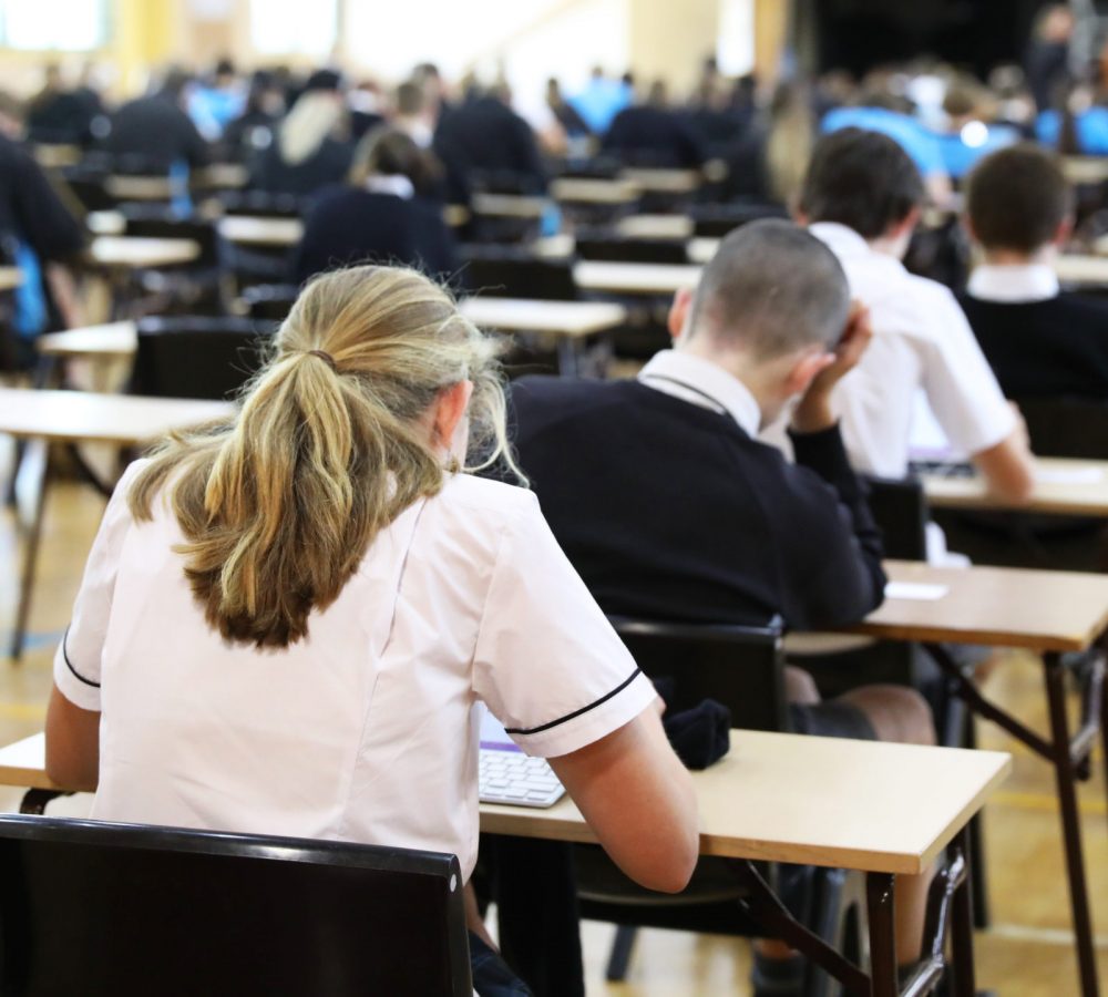 Anonymous,Students,In,Uniform,Sitting,An,Exam,Online,Using,Digital